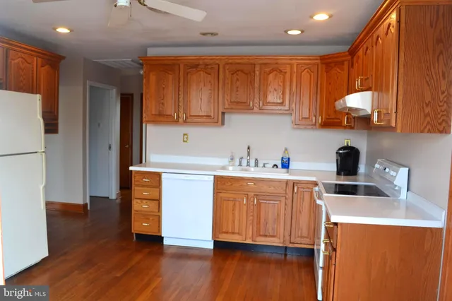 a kitchen with stainless steel appliances sink refrigerator and cabinets