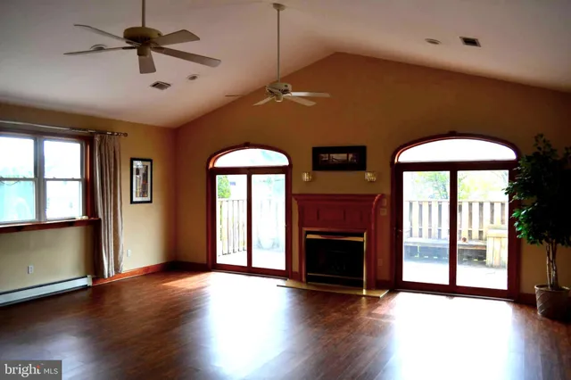 wooden floor fireplace and windows in an empty room