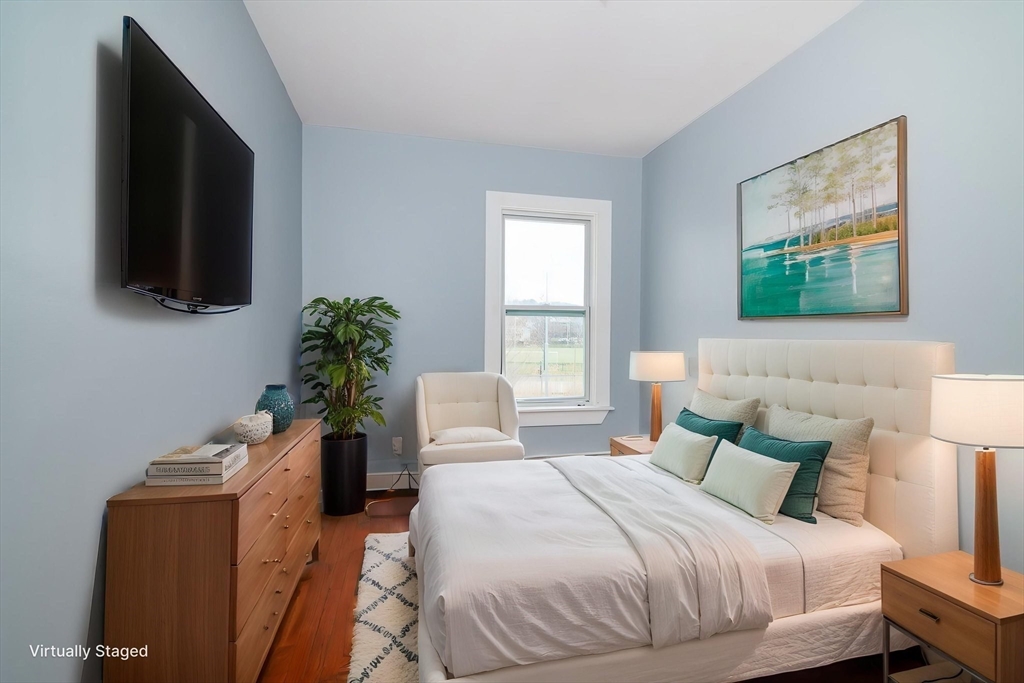 79 Gilbert Street Quincy, MA 02169 - Photo 18 of 38 a bedroom with a bed a flat screen tv and a potted plant