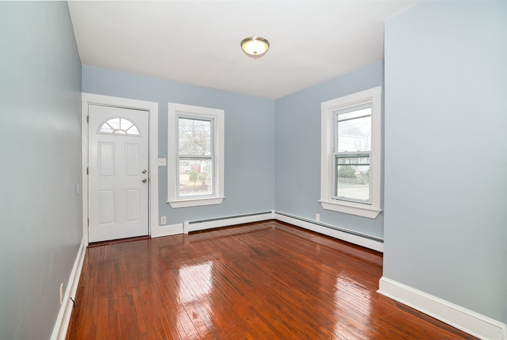 79 Gilbert Street Quincy, MA 02169 - Photo 7 of 38 an empty room with wooden floor and windows