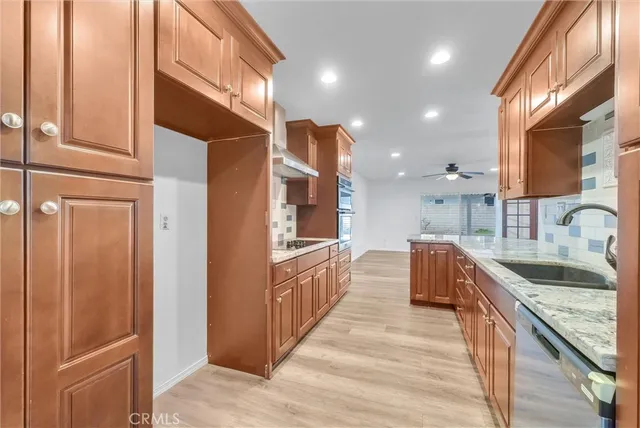 a large kitchen with stainless steel appliances granite countertop a sink and a refrigerator