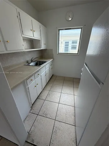 a kitchen with a stove a sink and cabinets