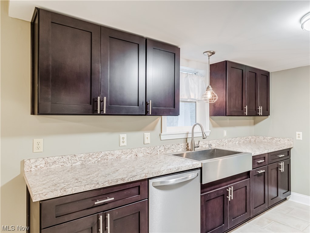 4349 Broadview Road Richfield, OH 44286 - Photo 12 of 20 Kitchen featuring dark brown cabinetry, hanging light fixtures, stainless steel dishwasher, and light tile floors