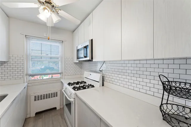 a kitchen with a stove a white cabinet and a granite counter tops