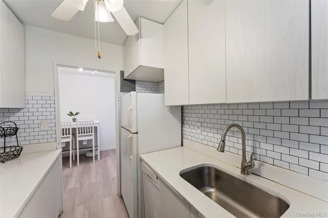 a kitchen that has a sink and a stove with wooden floor
