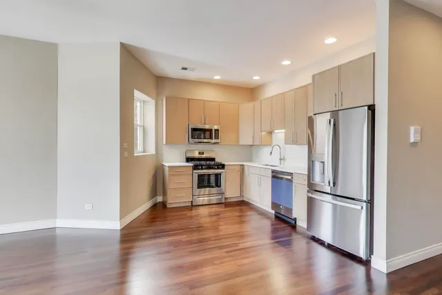 a kitchen with wooden floors and stainless steel appliances
