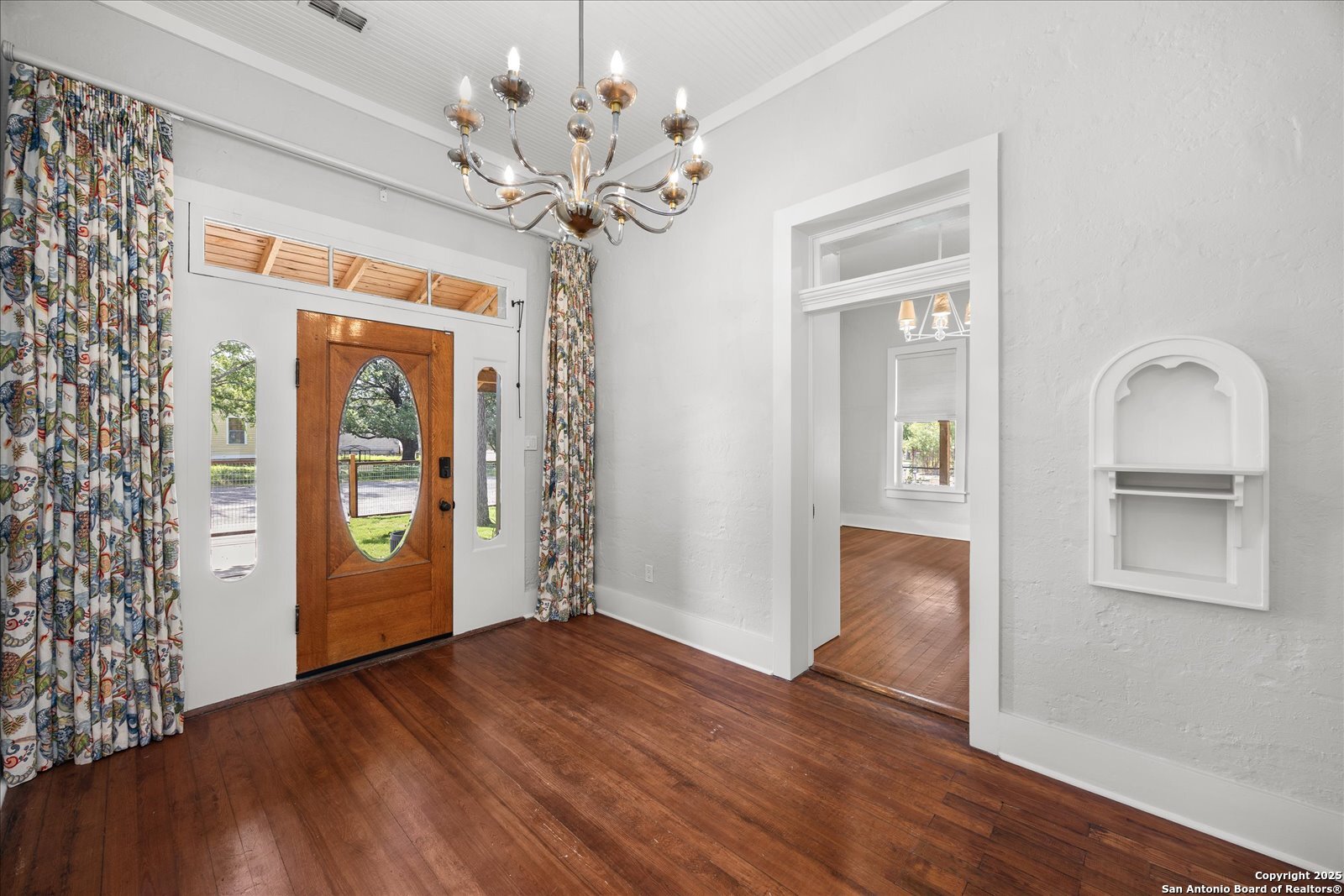 504 6th Street Comfort, TX 78013 - Photo 17 of 48 an empty room with wooden floor chandelier and windows