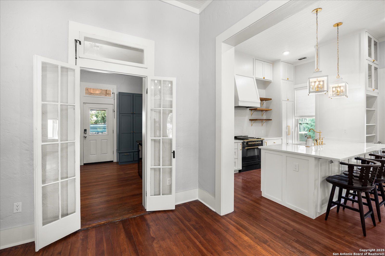 504 6th Street Comfort, TX 78013 - Photo 23 of 48 a kitchen with wooden floors and white cabinets