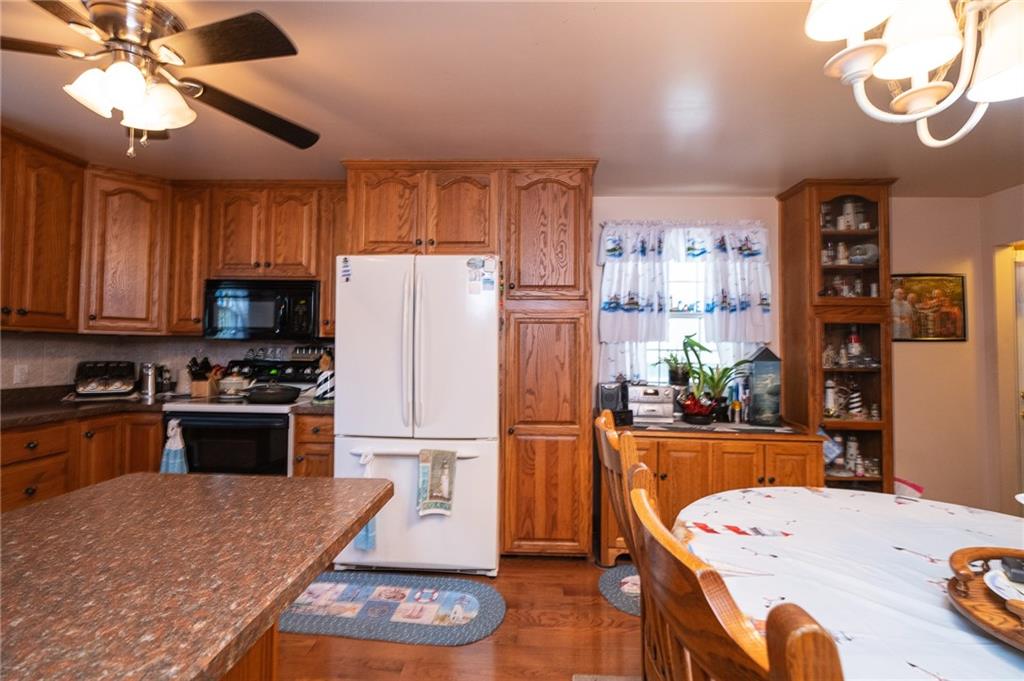 3114 Ellwood Road New Castle, PA 16101 - Photo 8 of 23 a kitchen with stainless steel appliances granite countertop a refrigerator a stove a sink dishwasher and a refrigerator with wooden floor