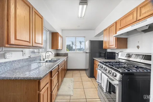 a kitchen with granite countertop sink and window