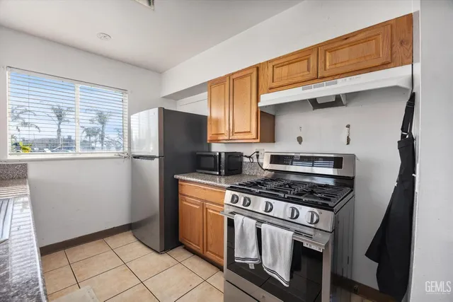 a kitchen with stainless steel appliances granite countertop a sink stove and cabinets