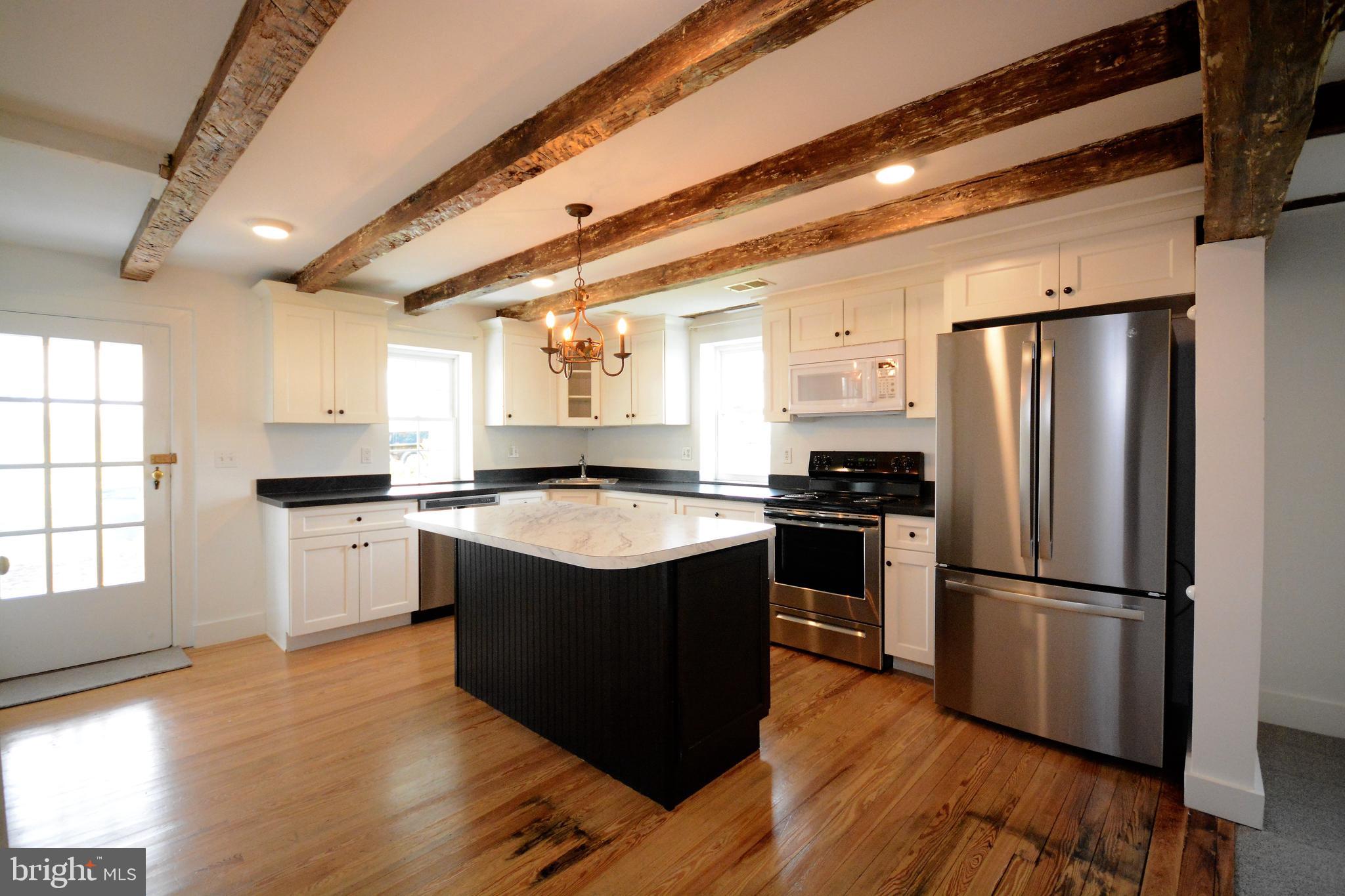 12108 Auburn Road Thurmont, MD 21788 - Photo 2 of 33 a kitchen with wooden floors and stainless steel appliances