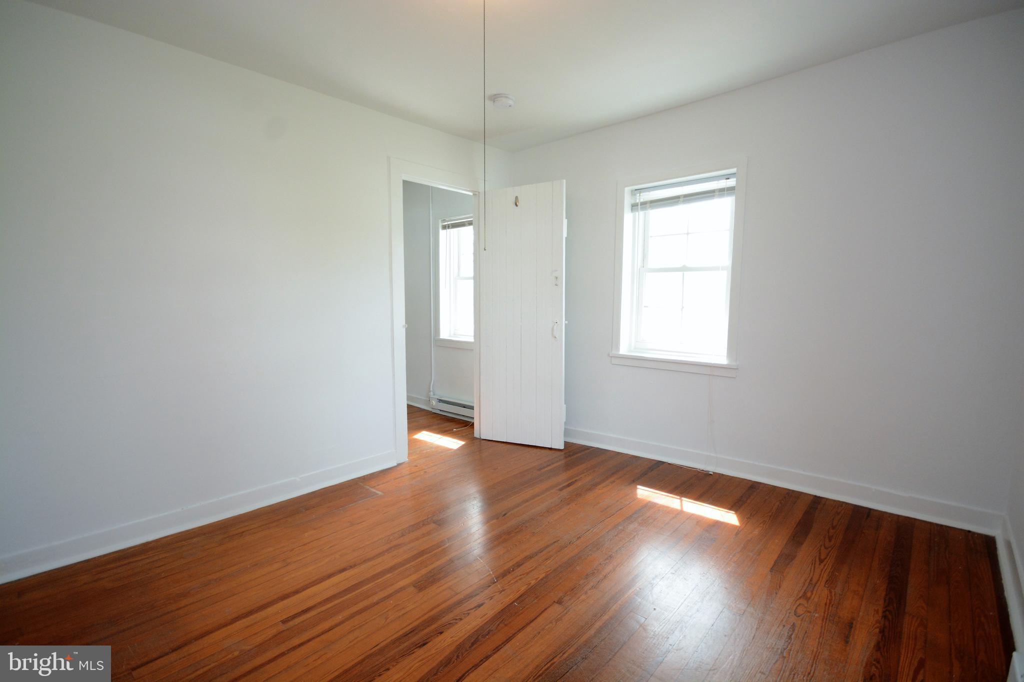 12108 Auburn Road Thurmont, MD 21788 - Photo 21 of 33 an empty room with wooden floor cabinet and windows