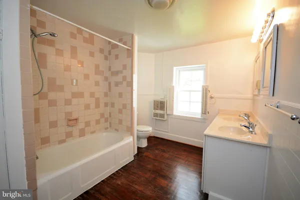 a bathroom with a tub a sink and a window