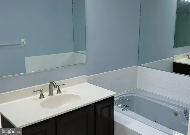 a bathroom with a sink vanity and tub