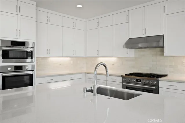 a view of a hallway with wooden floor and a living room