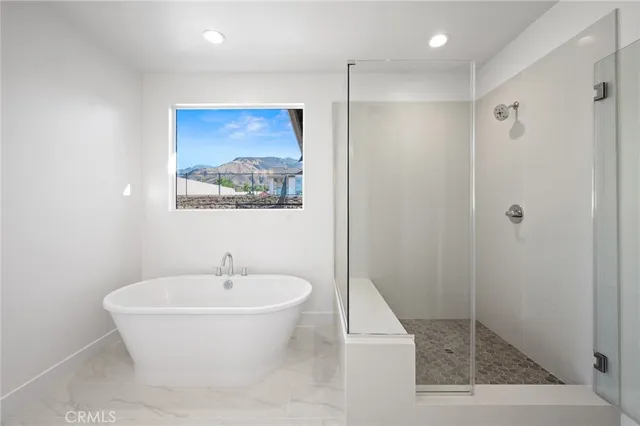 a front view of a house with a yard and mountain view in back