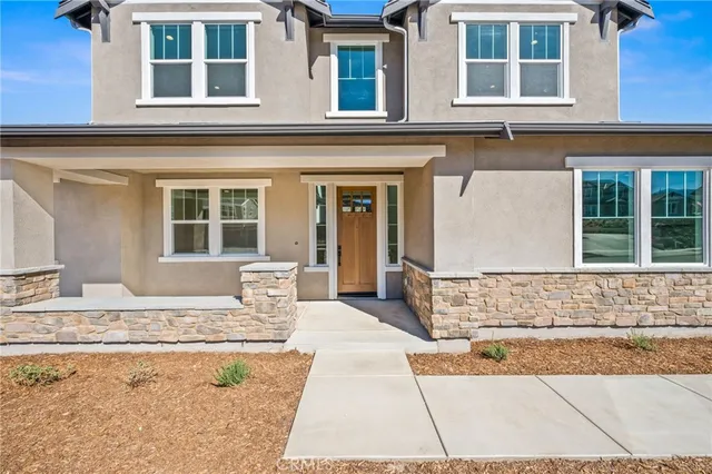 a large white kitchen with wooden floors stainless steel appliances and white cabinets