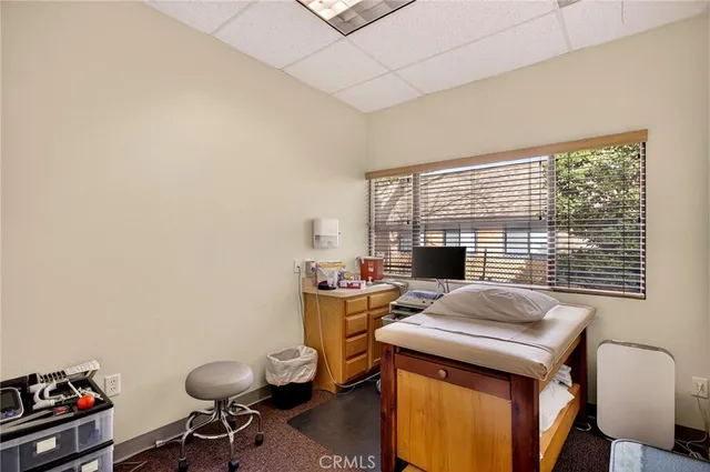 a view of a workspace with furniture and a window