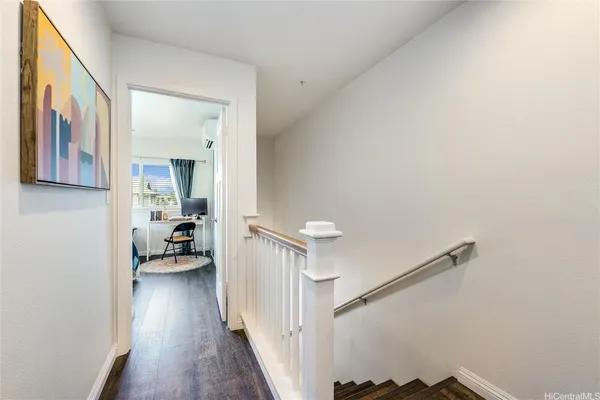 a view of a hallway with a livingroom and a hallway with wooden floor