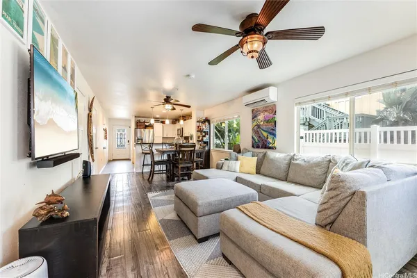 a living room with furniture ceiling fan and a floor to ceiling window