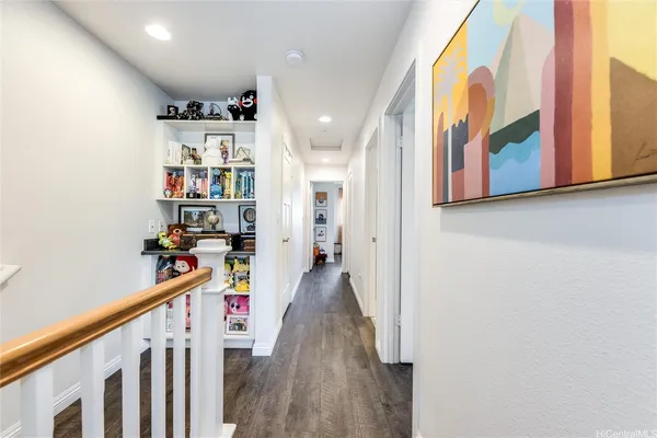 a view of a hallway with wooden floor and staircase