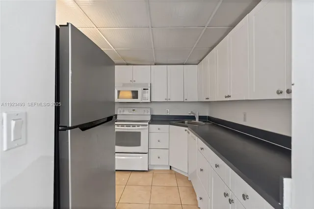 a kitchen with a refrigerator sink and cabinets