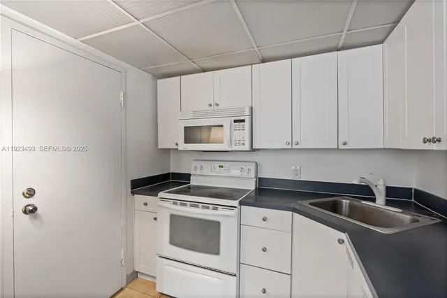 a kitchen with cabinets appliances a sink and a counter top
