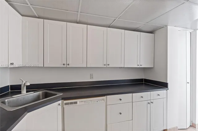 a kitchen with granite countertop white cabinets and sink