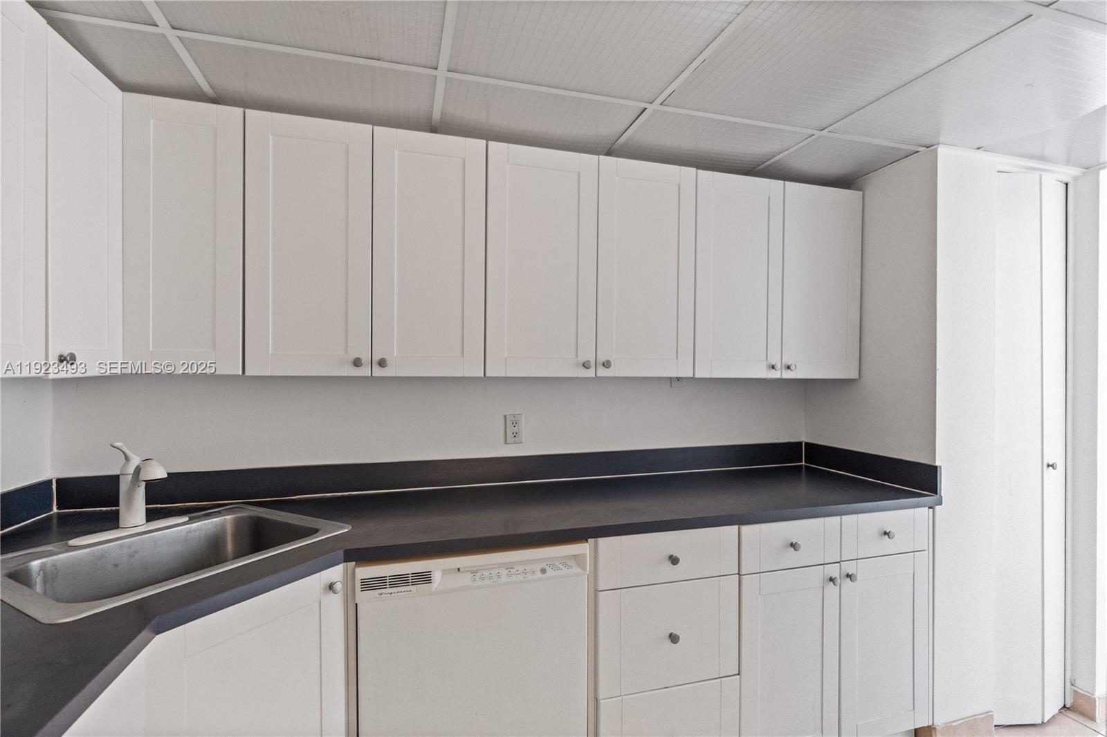 800 West Avenue, Unit 722 Miami Beach, FL 33139 - Photo 14 of 33 a kitchen with granite countertop white cabinets and sink