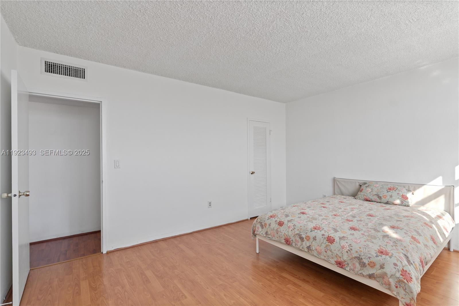 800 West Avenue, Unit 722 Miami Beach, FL 33139 - Photo 18 of 33 a bedroom with a bed and a wooden floor