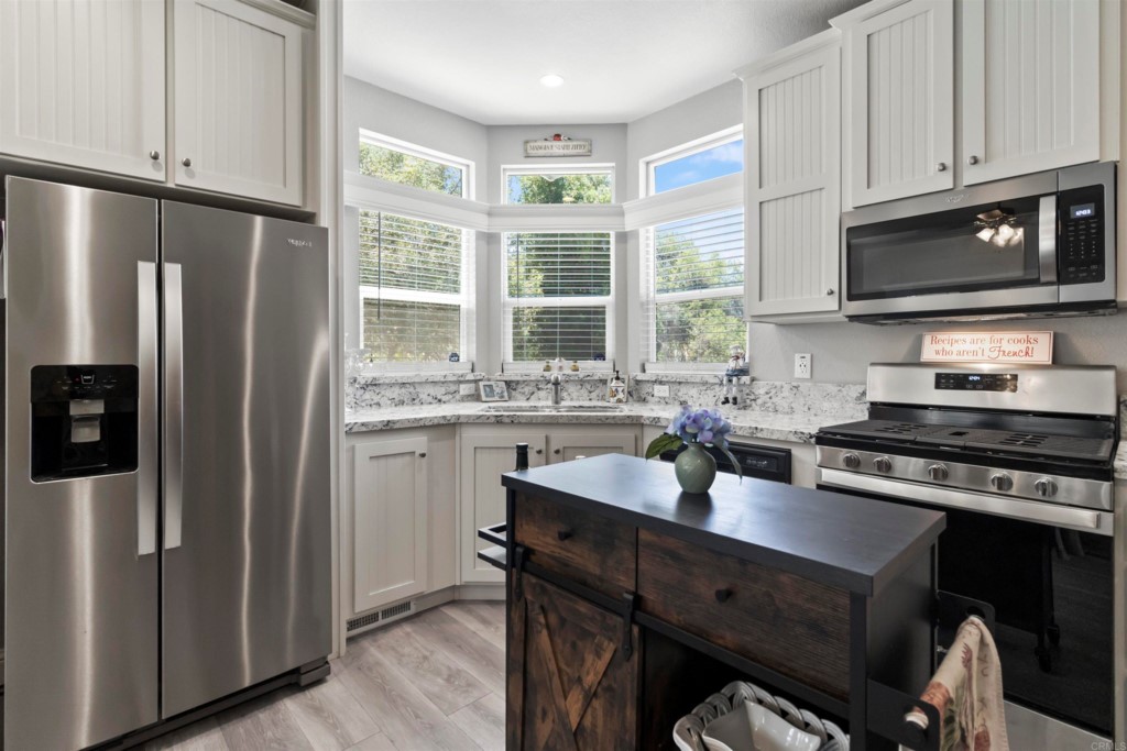 a kitchen with stainless steel appliances granite countertop a refrigerator stove and sink