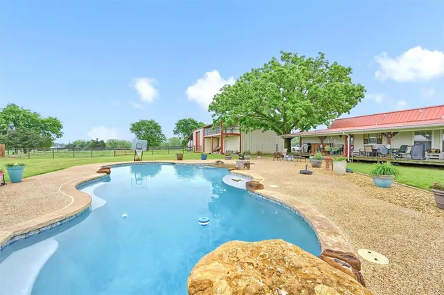 a view of a swimming pool with lounge chairs in patio