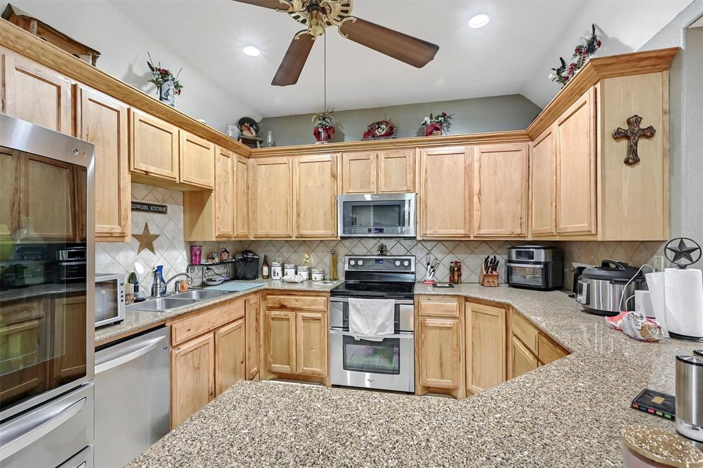 3138 Scarbrough Road Sadler, TX 76264 - Photo 17 of 40 a kitchen with stainless steel appliances granite countertop a sink a stove and refrigerator