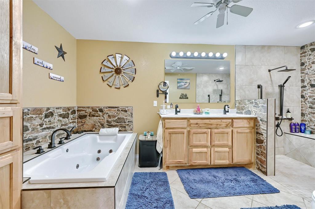 3138 Scarbrough Road Sadler, TX 76264 - Photo 29 of 40 a spacious bathroom with a sink a mirror and a bathtub