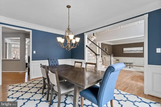 a kitchen with stainless steel appliances granite countertop wooden cabinets a sink dishwasher a stove and a refrigerator with wooden floor