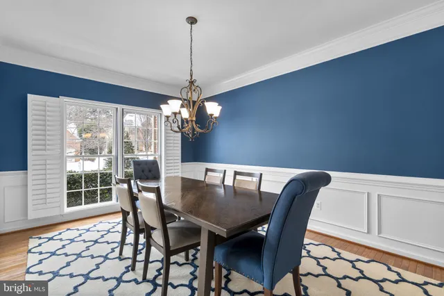 a dining room with furniture a chandelier and wooden floor