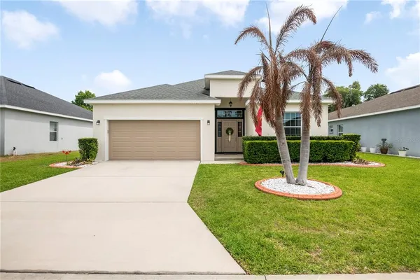a front view of a house with a yard and garage