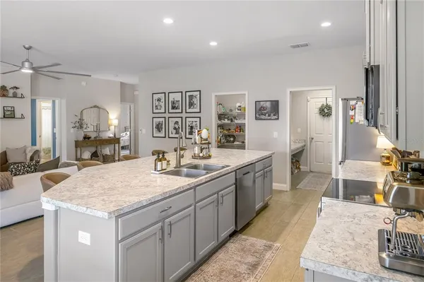 a large kitchen with kitchen island a sink stove and wooden floor