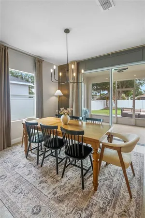 a dining room with furniture a chandelier and wooden floor