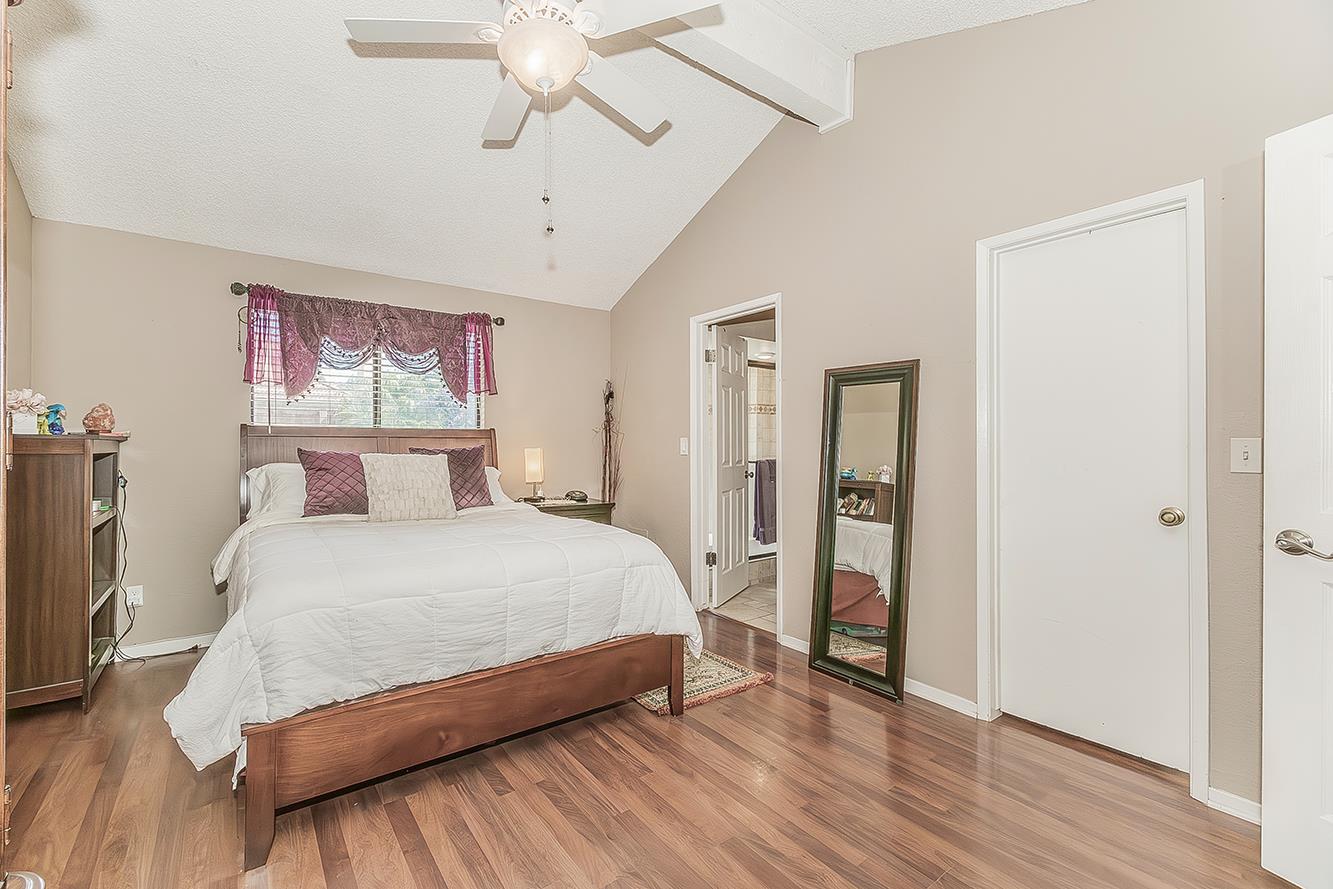 1908 East Niles Avenue Fresno, CA 93720 - Photo 14 of 30 a bedroom with a large bed and a chandelier