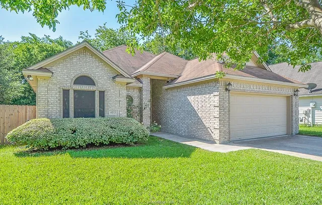 a front view of a house with a garden and yard