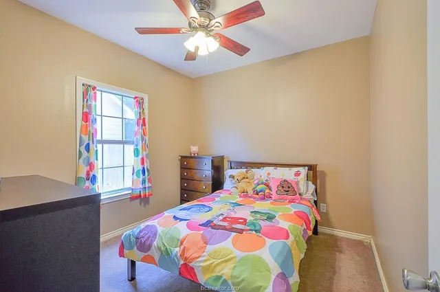 a bedroom with a bed and a painting on the wall