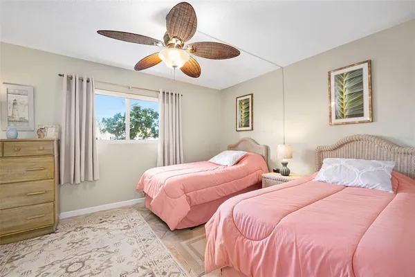 a bedroom with two separate beds and a window