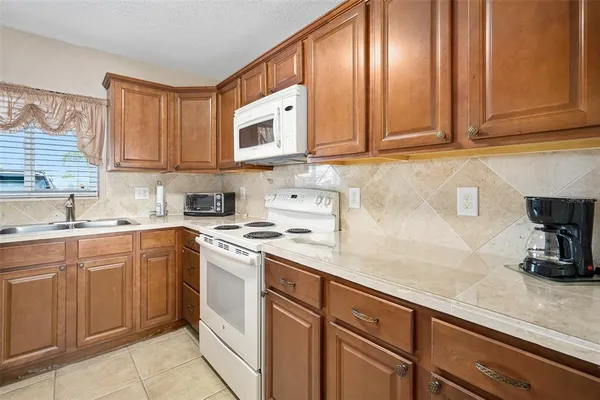 a kitchen with stainless steel appliances granite countertop a sink stove and microwave