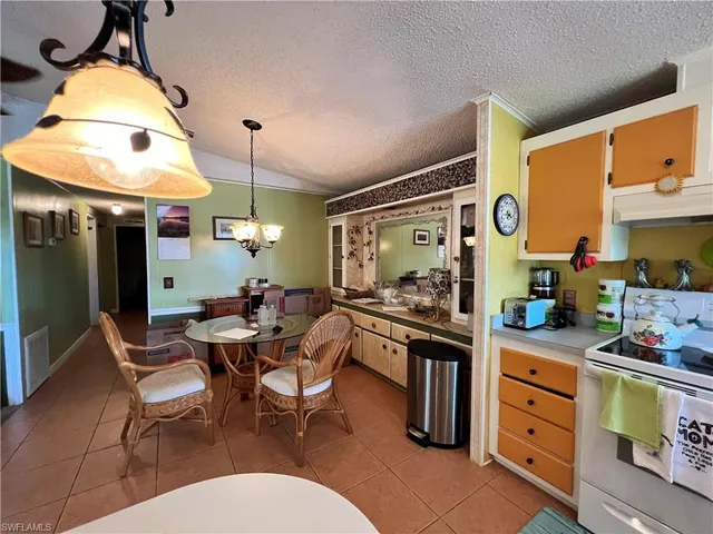 a kitchen with stainless steel appliances kitchen island granite countertop a table and chairs in it