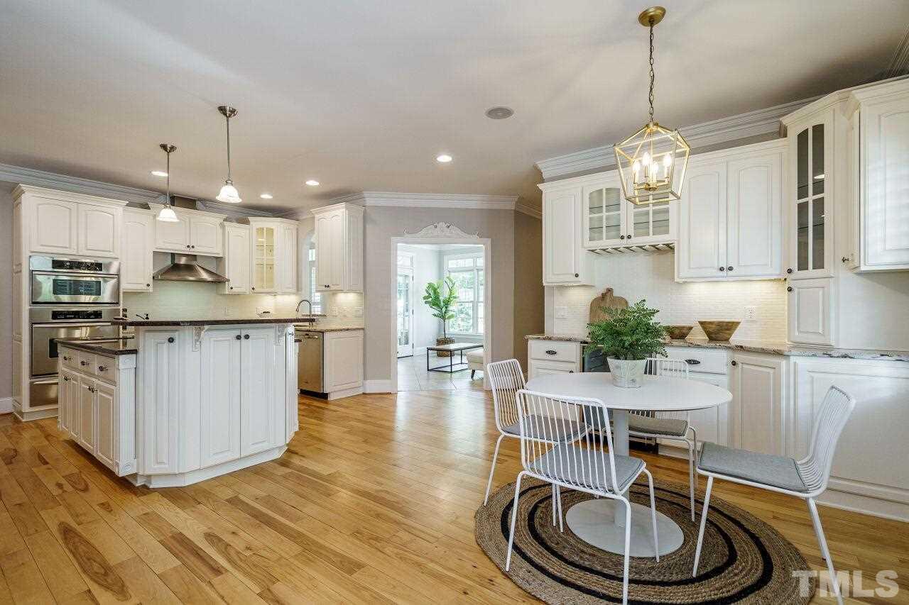 4813 Patton Ridge Court Raleigh, NC 27612 - Photo 11 of 30 a kitchen with stainless steel appliances granite countertop a refrigerator a stove a sink dishwasher and white cabinets with wooden floor
