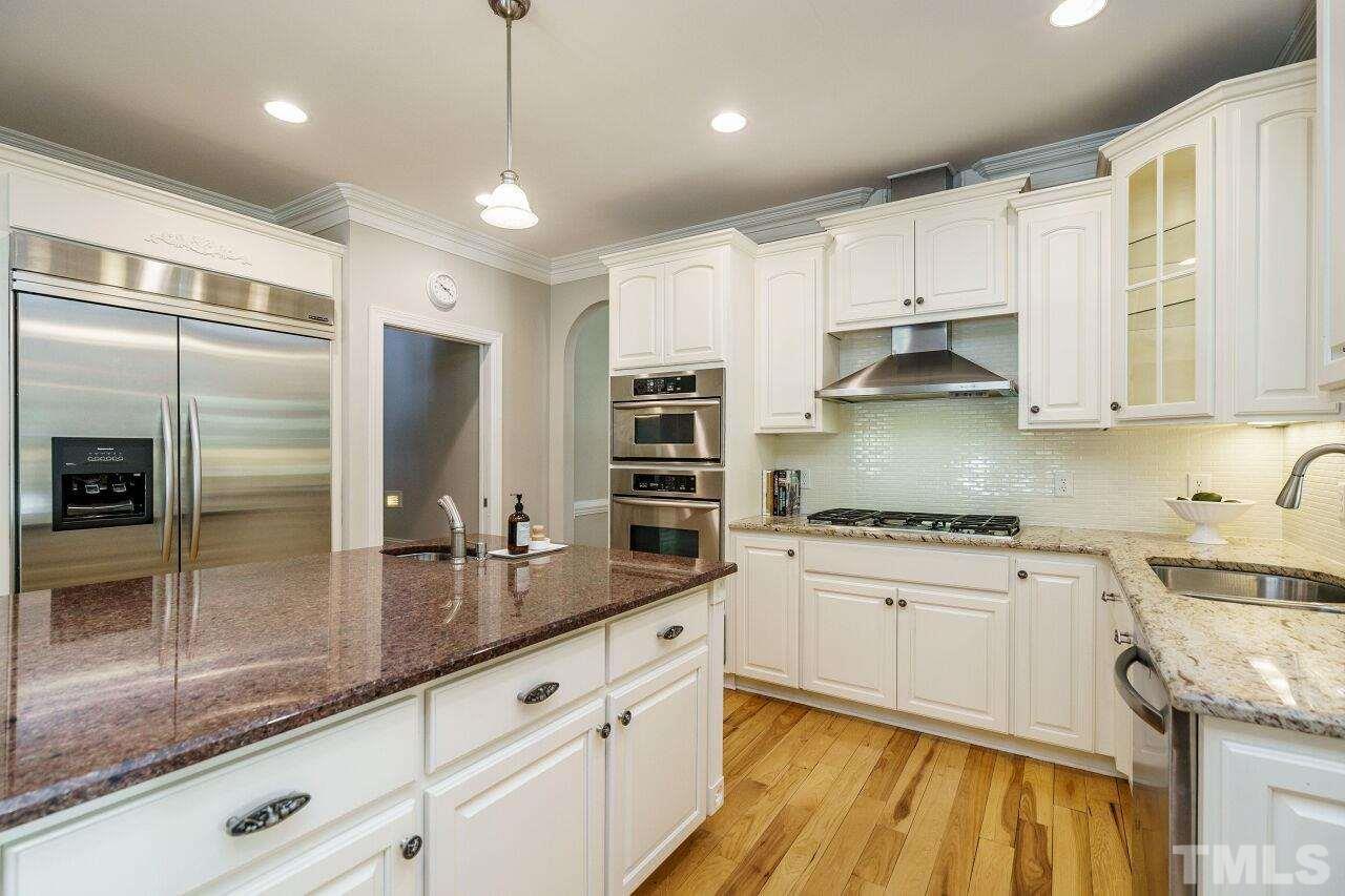 4813 Patton Ridge Court Raleigh, NC 27612 - Photo 12 of 30 a kitchen with stainless steel appliances granite countertop a sink a stove and a refrigerator