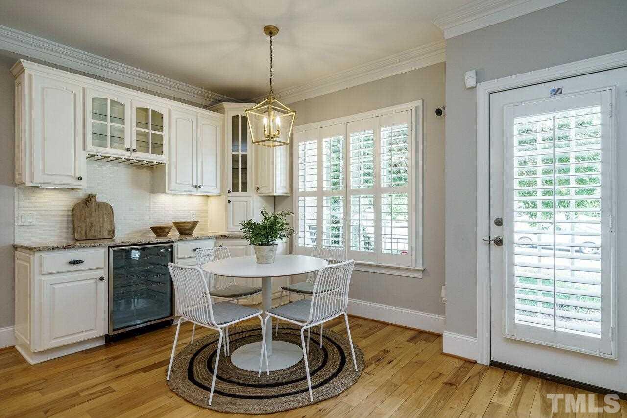 4813 Patton Ridge Court Raleigh, NC 27612 - Photo 13 of 30 a dining room with wooden floor a chandelier a wooden table and chairs