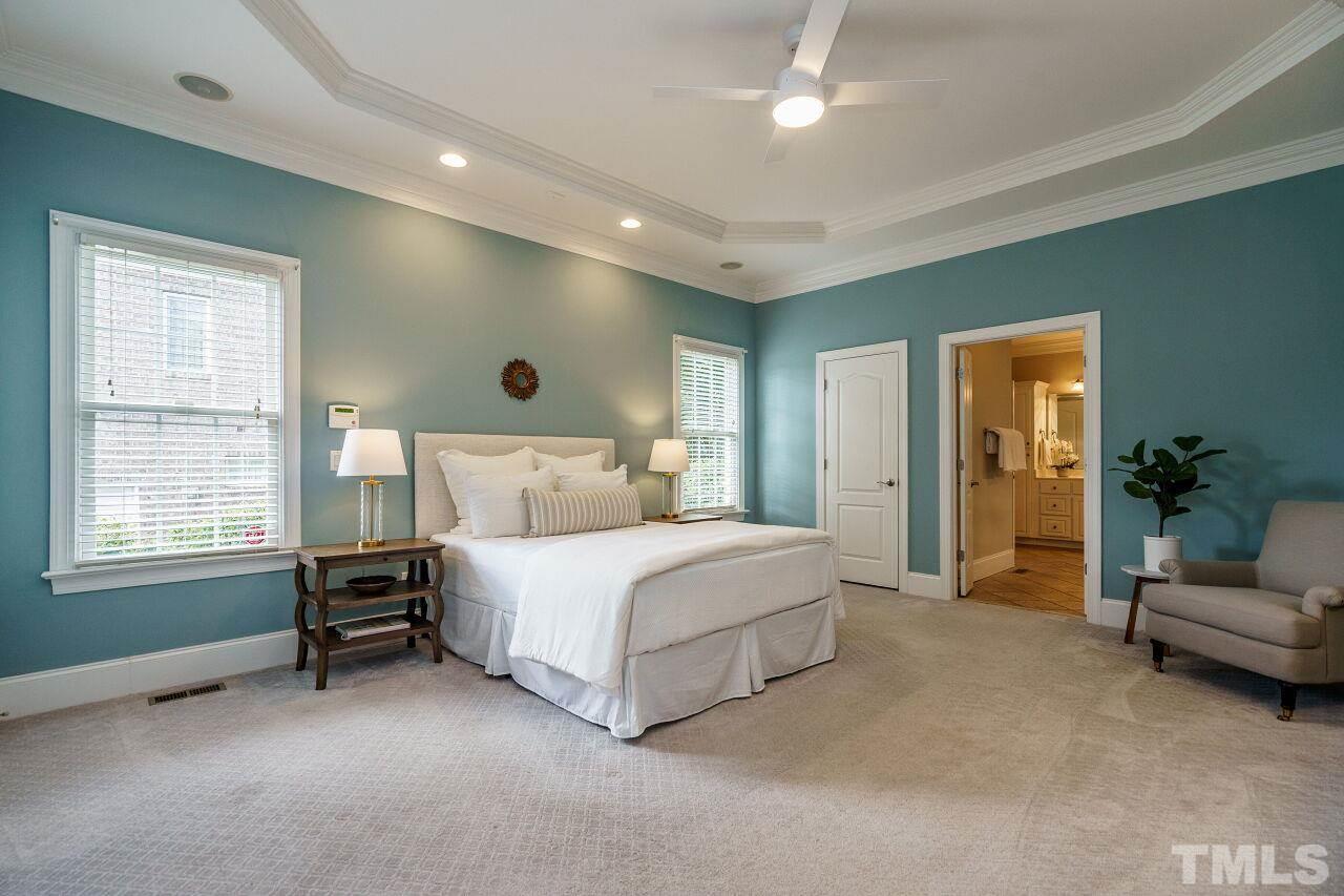 4813 Patton Ridge Court Raleigh, NC 27612 - Photo 15 of 30 a spacious bedroom with a bed a couch and large window